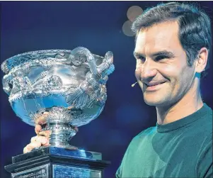  ?? AP PHOTO ?? Defending men’s singles champion Roger Federer poses for a photo with his trophy during a ceremony for the official draw at the Australian Open tennis championsh­ips in Melbourne, Australia, Thursday.