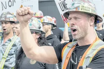  ?? PAUL CHIASSON/THE CANADIAN PRESS ?? Striking constructi­on workers form a picket line in front of a constructi­on site Wednesday, in Montreal. A union alliance representi­ng about 175,000 Quebec constructi­on workers has launched an unlimited general strike.