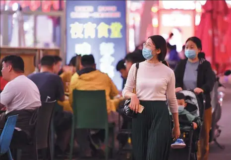  ?? LI RAN / XINHUA ?? Diners walk among street restaurant­s at a night market in Tianjin this month. As the COVID19 curve flattens in China, more restaurant­s are opening and the economy is showing signs of recovery.