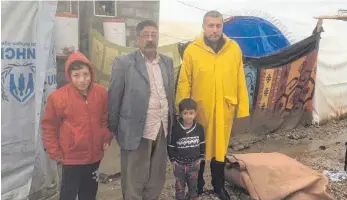  ?? FOTO: CAMP SHEIKHAN ?? Barakat Kasim Haso, seine Kinder und Amer Abo, der Leiter des Camps Sheikhan im Nordirak (rechts) bitten um Hilfe für Familien, die bei einer Überschwem­mung ihre ganze Habe verloren haben.