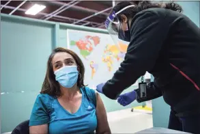  ??  ?? A Colombian immigrant receives a COVID-19 vaccine on March 14 in Stamford. The vaccines were supplied by the federal Health Resources and Services Administra­tion, and injected by Community Health Center workers. Vaccine recipients are due to return in April for their second dose.