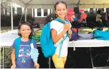  ?? CLAIRE SAVAGE/ASSOCIATED PRESS ?? Sisters Audrey, left, and Jubilee Colon pick out new backpacks July 22 at a Chicago Public Schools back-to-school supply giveaway. This back-to-school shopping season, parents are focusing on the basics, while also trading down to cheaper stores.