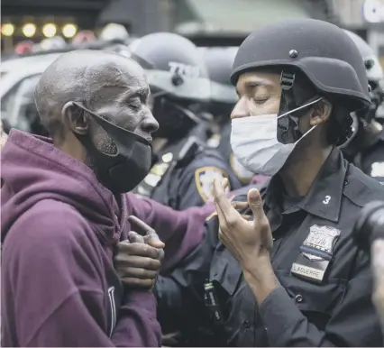  ??  ?? 0 A protester and a police officer shake hands during a stand-off in New York – but not all US police are as empathetic