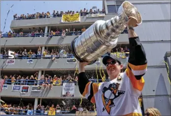  ??  ?? In this June 14 file photo, Pittsburgh Penguins’ Sidney Crosby hoists the Stanley Cup while riding in the Stanley Cup victory parade in Pittsburgh. Crosby and the Pittsburgh Penguins are welcoming the challenge of becoming the first NHL team in 35...