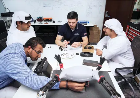  ?? Antonie Robertson / The National ?? Students work on applicatio­ns for unmanned aerial vehicles at the Lockheed Martin lab in Masdar City