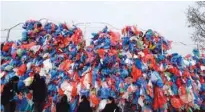  ?? - AFP ?? SUBMIT CLAIM: Nepali volunteers and school children tie up used plastic bags to make a sculpture representi­ng the Dead Sea in a bid to set a new world record for the largest sculpture made out of used plastic bags in Kathmandu on December 5, 2018.