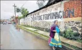  ?? REUTERS ?? ▪ A woman walks past a graffiti reading ‘No political parties, Yes to selfdeterm­ination’ in the Purepecha town.