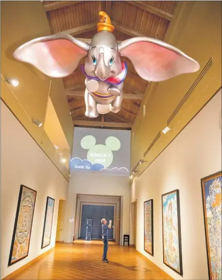  ?? Allen J. Schaben Los Angeles Times ?? DUMBO FLIES over the entrance to the Bowers Museum’s “Inside the Walt Disney Archives: 50 Years of Preserving the Magic.”