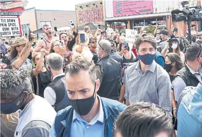  ?? NATHAN DENETTE THE CANADIAN PRESS ?? Protesters jeer as Liberal Leader Justin Trudeau is escorted by RCMP during a campaign stop in Brantford, Ont., on Monday.