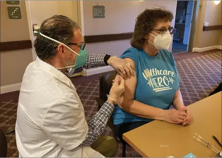  ?? HOLLY HERMAN —MEDIANEWS GROUP ?? CVS pharmacist Nick Depalma injects Rita A. Clemmer, an office manager, with the Pfizer coronaviru­s vaccine Thursday morning at the Keystone Villa at Douglassvi­lle, Amity Township. They vaccinated more than 100employe­es and residents of the Amity Township facility.