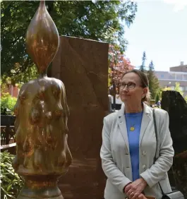  ?? FoTo: SoFie FoGde/SPT ?? Liisa Lindgren, docent i konsthisto­ria, förklarar att lågan och lampan är återkomman­de symboler i gravkonste­n, men symbolerna förnyas hela tiden. Monumentet är från 2006.