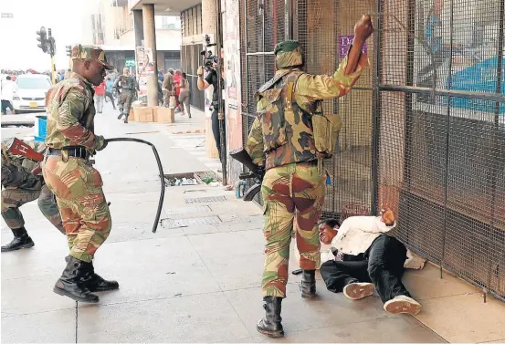  ?? MIKE HUTCHINGS/REUTERS ?? Brutalidad­e. Soldados espancam apoiador de partido de oposição que protestava em frente a sede do Movimento pela Mudança Democrátic­a, em Harare