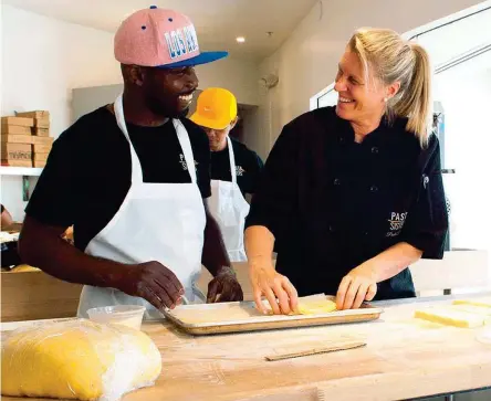  ??  ?? In cucina Paola Da Re, 55 anni, con Franklin, addetto a tirare la pasta nel ristorante di Culver. Fra i clienti dei suoi catering Paramount e Sting