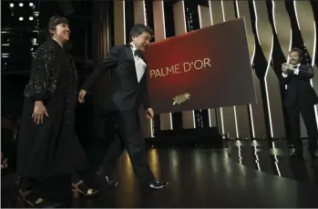  ??  ?? Director Hirokazu Kore-eda (center) walks on stage to receive the Palme d’Or for the film Shoplifter­s during the closing ceremony of the 71st internatio­nal film festival, Cannes, southern France, on Saturday. VIANNEY LE CAER