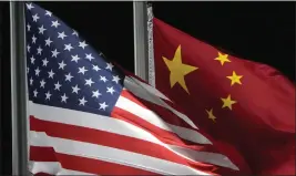  ?? KIICHIRO SATO — THE ASSOCIATED PRESS, FILE ?? The American and Chinese flags wave ahead of the 2022 Winter Olympics. U.S. and Chinese defense officials met this week to discuss unsafe and aggressive ship and aircraft incidents between the two militaries in the Pacific region.