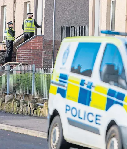  ?? Picture: Steven Brown. ?? Police officers carry out door to door inquiries at the scene of the murder of Kevin Byrne at Alison Street, Kirkcaldy.