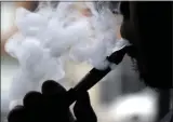  ?? NAM Y. HUH—ASSOCIATED PRESS ?? In this April 23, 2014file photo, a man smokes an electronic cigarette in Chicago. Teen vapers prefer Juul and mint is the #1flavor among many of them, suggesting a shift after the company’s fruit and dessert flavors were removed from retail stores, new U.S. research suggests. The results are in a pair of studies published Tuesday, Nov. 5, 2019, including a report from the Food and Drug Administra­tion and federal Centers for Disease Control and Prevention indicating that the U.S. teen vaping epidemic shows no signs of slowing down.