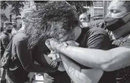  ?? RAMON ESPINOSA AP ?? Plaincloth­es police detain an anti-government protester during a protest in Havana on July 11. Hundreds took to the streets in several cities in Cuba.