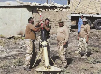  ?? AP PHOTO ?? GEARING UP: Iraqi soldiers prepare a mortar before storming Mosul, Iraq, yesterday.