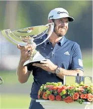  ?? John Bazemore, The Associated Press ?? Dustin Johnson holds up the FedEx Cup trophy after winning the Tour Championsh­ip golf tournament on Monday at Lake Golf Club in Atlanta.