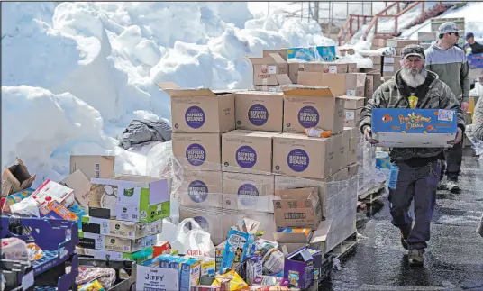  ?? Marcio Jose Sanchez The Associated Press ?? Food is distribute­d out of a parking lot Wednesday after a series of storms in Crestline, Calif.