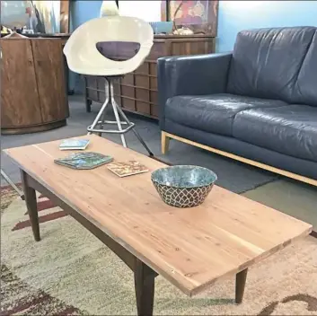  ?? Patricia Sheridan/Post-Gazette photos ?? An upcycled coffee table made from an old cedar chest is $90, and a white fiberglass swivel bar stool is $95 at Pittsburgh Furniture Co. in Lawrencevi­lle.