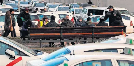  ??  ?? Un grupo de taxistas reunidos a las puertas del recinto ferial de Ifema, ayer durante el cuarto día de huelga del sector.