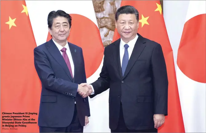  ?? Photo: Xinhua ?? Chinese President Xi Jinping greets Japanese Prime Minister Shinzo Abe at the Diaoyutai State Guesthouse in Beijing on Friday.