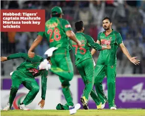  ??  ?? Mobbed: Tigers’ captain Mashrafe Mortaza took key wickets