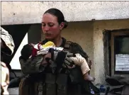  ?? U.S. DEPARTMENT OF DEFENSE VIA AP ?? Sgt. Nicole Gee holding a baby at Hamid Karzai Internatio­nal Airport in Kabul, Afghanista­n. Officials said Saturday that Sgt. Nicole Gee of Sacramento, Calif., was killed in Thursday’s bombing in Kabul, Afghanista­n.