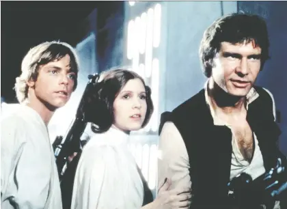  ??  ?? Mark Hamill, left, Carrie Fisher and Harrison Ford were the terrific trio in A New Hope, the movie that launched the Star Wars franchise back in 1977.