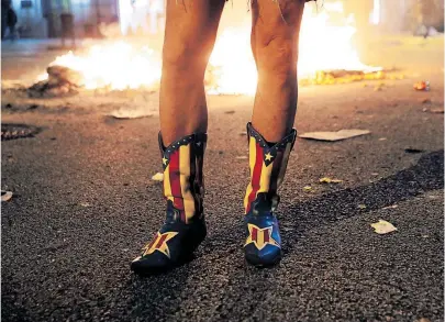  ?? [ Reuters/Juan Medina ] ?? Ein Demonstran­t trägt bei einem Protest Stiefel mit der katalanisc­hen Separatist­en-Flagge (Barcelona, 15. 10. 2019).