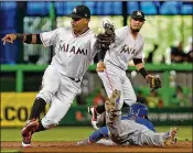  ?? PATRICK FARRELL / MIAMI HERALD ?? The Mets’ Amed Rosario slides safely into second base in the first inning Sunday as the Marlins’ Starlin Castro bobbles the ball.