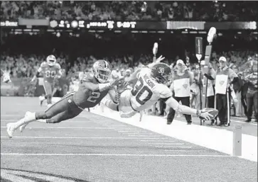  ?? Tom Pennington Getty Images ?? MACK WILSON of Alabama avoids a tackle by Clemson’s Kelly Bryant and completes an 18-yard pick six in style during the third quarter of Monday’s game. It extended Alabama’s lead to 24-6, the game’s final score.