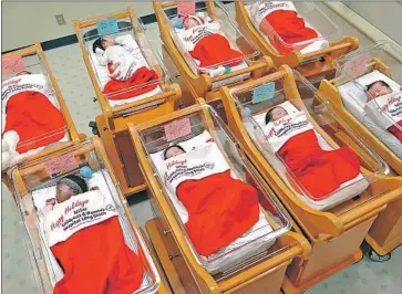  ?? Christina House For The Times ?? NEWBORN BABIES are tucked into Christmas stockings at a Long Beach hospital in 2014. In America, black women are three to four times more likely than white women to die immediatel­y before or after childbirth.