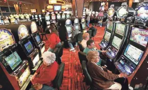  ?? M.P. KING / GREEN BAY PRESS-GAZETTE ?? Patrons work the slot machines at the North Star Mohican Casino in Bowler. The casino is run by the Stockbridg­e-Munsee tribe. The Ho-Chunk are planning to expand their facility nearby.