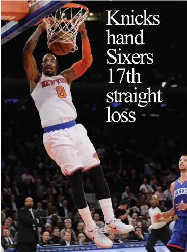  ?? ASSOCIATED PRESS ?? New York Knicks' J.R. Smith dunks the ball during the first half of an NBA basketball game as Philadelph­ia 76ers' Michael Carter- Williams trails the play in New York.