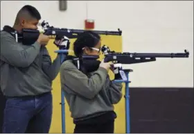 ?? MARLA BROSE/ALBUQUERQU­E VIA AP ?? A group of JROTC shooters compete in the 2018 New Mexico Junior Olympic Qualifier for sport and precision air rifles at Cibola High School in Albuquerqu­e, N.M., for the chance to compete at the National Junior Olympic Championsh­ips in Ohio in June.