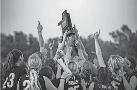  ?? NATHAN J. FISH/THE OKLAHOMAN ?? The Washington Warriors hoist the 2022 Class 4A state championsh­ip trophy after ending Dale’s slowpitch softball title reign.