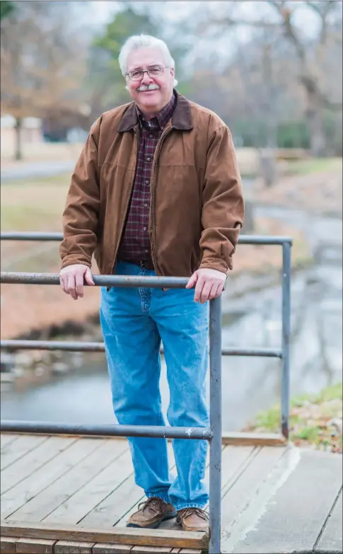  ?? WILLIAM HARVEY/RIVER VALLEY & OZARK EDITION ?? Mack Hollis, director of Russellvil­le Recreation and Parks, stands on a bridge near City Park. He will retire Jan. 26 after 35 years as director and 38 years in the department. During his tenure, Hollis has seen the number of parks grow from eight to...