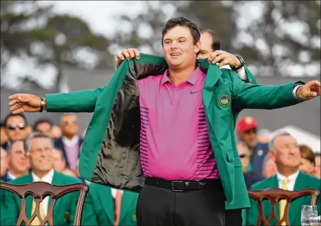  ?? CONTRIBUTE­D BY JASON GETZ ?? Patrick Reed is awarded the green jacket after holding off Rickie Fowler and Jordan Spieth to win the 82nd Masters at Augusta National on Sunday. “Growing up, you always think, ‘This putt is to win the Masters. This putt is to win the green jacket.’...