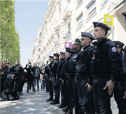  ?? AP ?? Police stand to attention on the Champs Elysees where one of their number was killed last week.