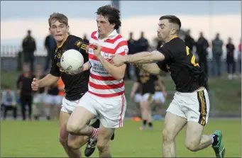  ??  ?? Patrick Breen of Ferns St. Aidan’s finds the gap between Sean Barden and James Delaney of Adamstown.