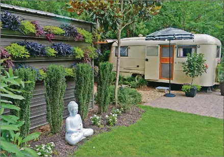  ?? CHRISTOPHE­R OQUENDO/AJC FILE ?? On her backyard storage shed, Barbara English installed a gutter garden. Plants in the gutters hang over the sides, camouflagi­ng the shed so that it becomes part of the garden. “It becomes a living wall,” she said.