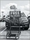  ?? BRIAN CASSELLA/CHICAGO TRIBUNE ?? Flu shots are administer­ed to drivers in the parking lot of a Jewel-Osco in Highland Park on Sept. 24.