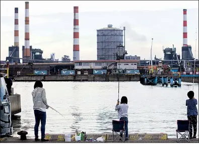  ?? Bloomberg News/TOMOHIRO OHSUMI ?? People fish across from a Kobe Steel Ltd. plant in Kakogawa, Hyogo, Japan on Saturday. The company said Tuesday that it is cooperatin­g with the U.S. Department of Justice in an investigat­ion of claims that it falsified certificat­ions on the strength...