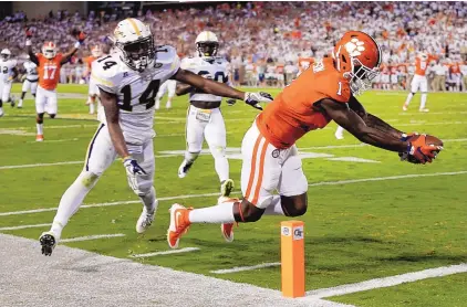  ?? JOHN BAZEMORE/ASSOCIATED PRESS ?? Clemson wide receiver Trevion Thompson (1) is pushed out of bounds by Georgia Tech defensive back Corey Griffin (14) as Thompson reaches for the end zone after catching a pass from Tigers QB Deshaun Watson in Thursday night’s game.