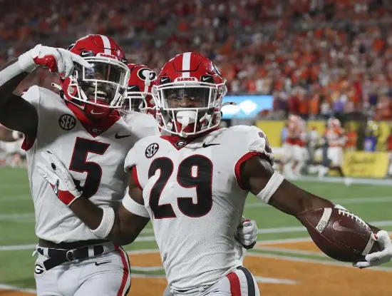  ?? Curtis Compton, Atlanta Journal-constituti­on ?? Georgia defensive back Christophe­r Smith, right, celebrates with Kelee Ringo after intercepti­ng a Clemson pass and returning it for a touchdown during the second quarter on Saturday in Charlotte, N.C.