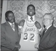  ?? ASSOCIATED PRESS FILE PHOTO ?? Earvin “Magic” Johnson, second from left, holds a Los Angeles Lakers uniform at New York’s Plaza Hotel, Monday, June 26, 1979, where he was selected by the Lakers in the first round of the National Basketball Associatio­n draft.