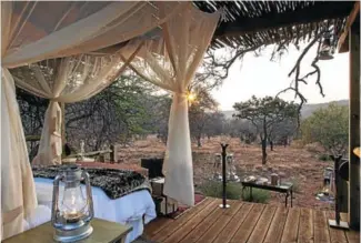  ??  ?? Tintswalo Lapalala offers a romantic ‘sleep-out experience’, above, and dining on the main deck overlookin­g the bush, left.